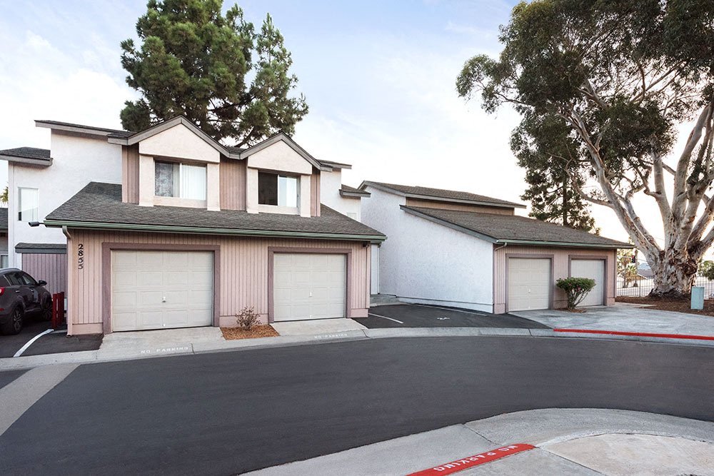 a house with two garages and a street in front of it