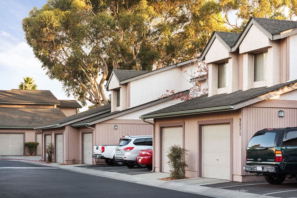 a row of houses with cars parked in front of them