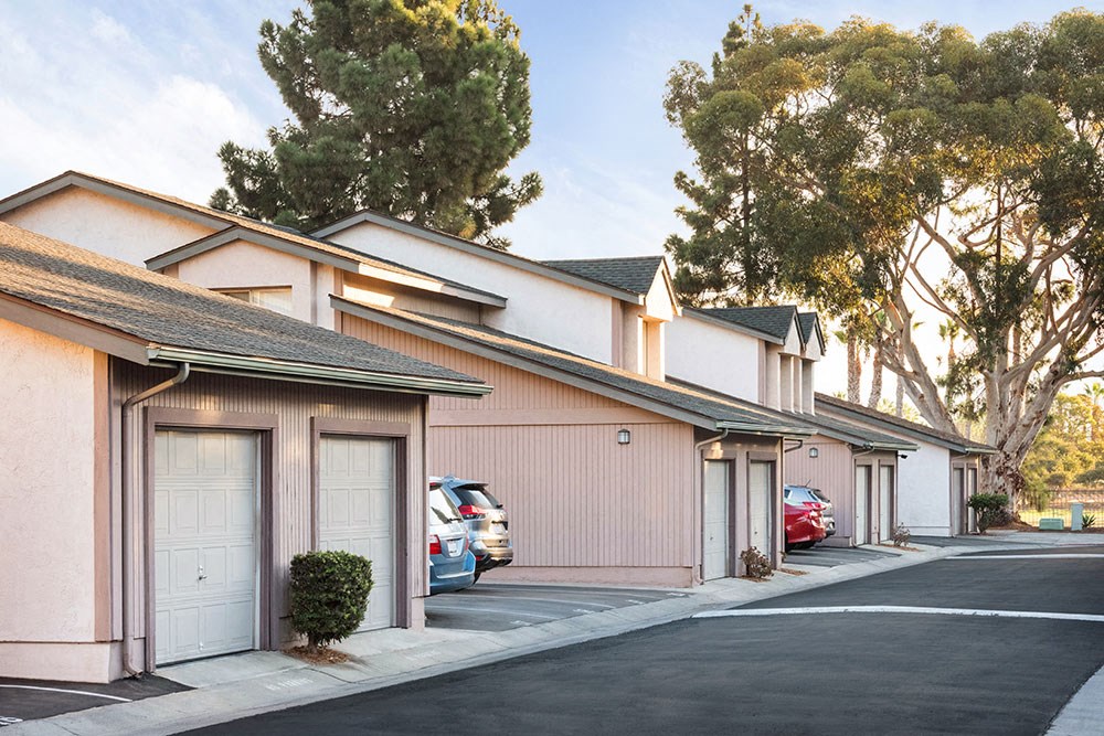 a row of buildings with cars parked in front of them