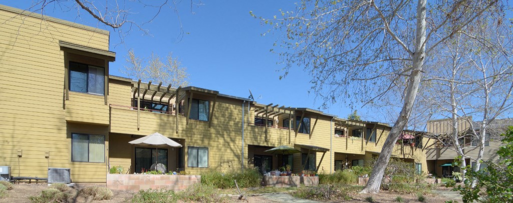 a row of houses with yellow siding and balconies