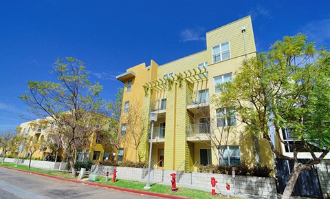 a row of yellow apartment buildings on the side of a street