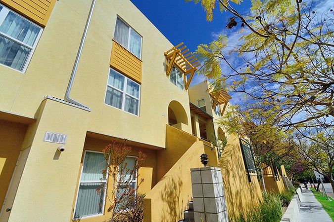 a yellow building with a sidewalk in front of it