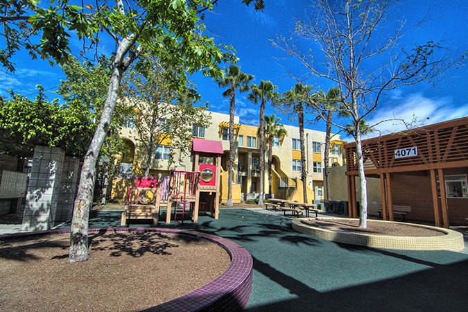 a courtyard with trees and buildings in the background