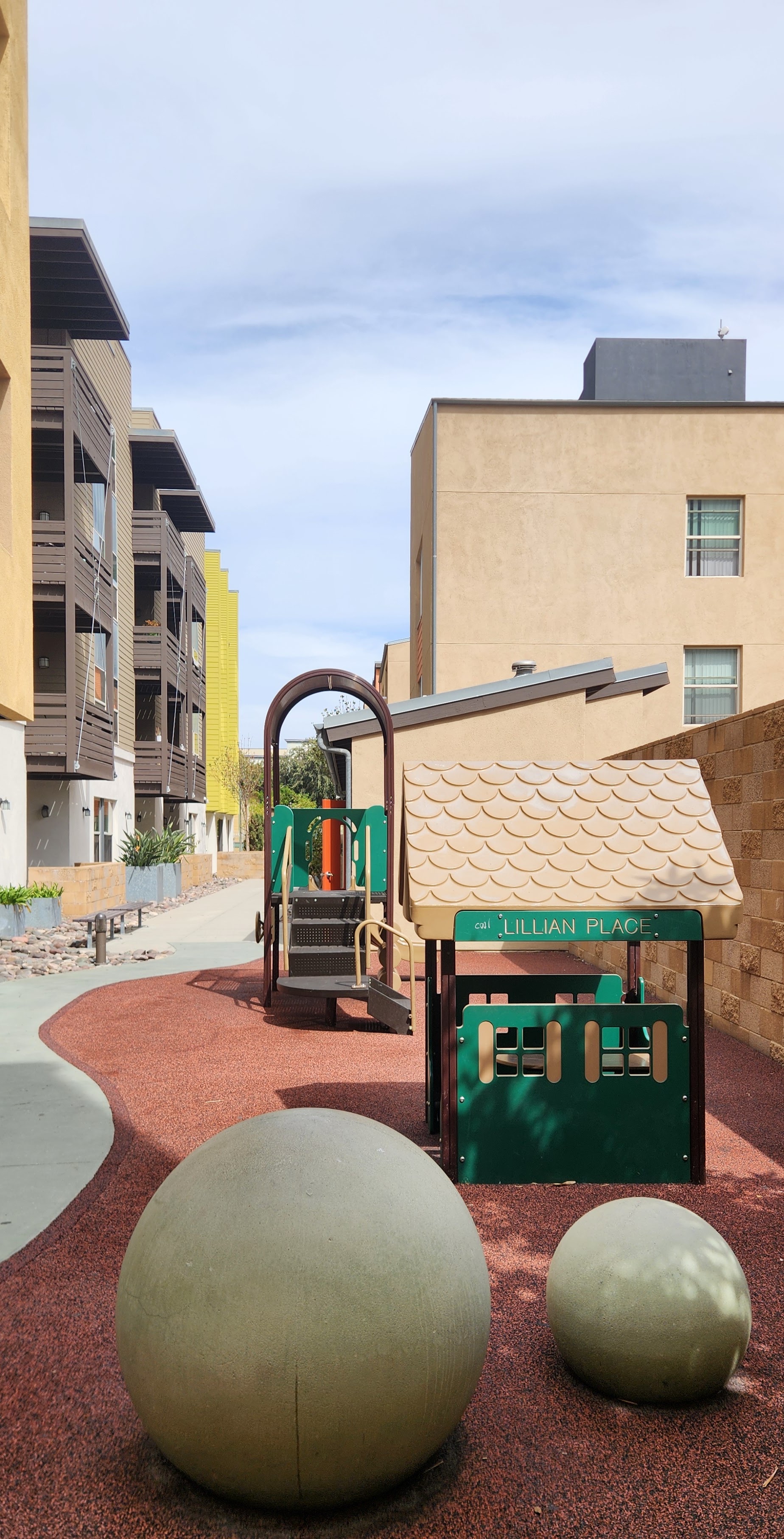 A playground with a slide and two large balls.