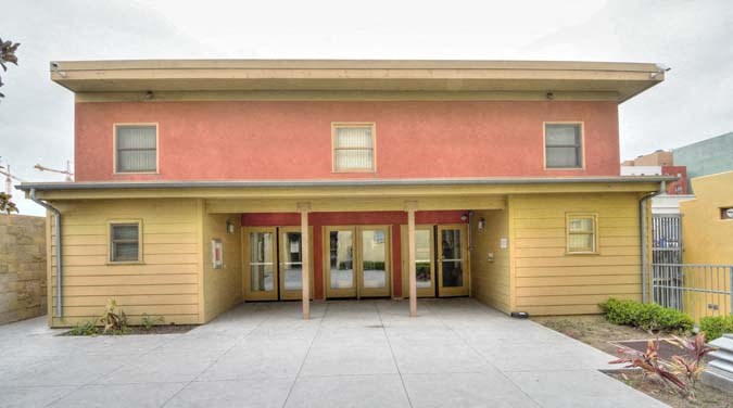 the front of a yellow and red building with doors