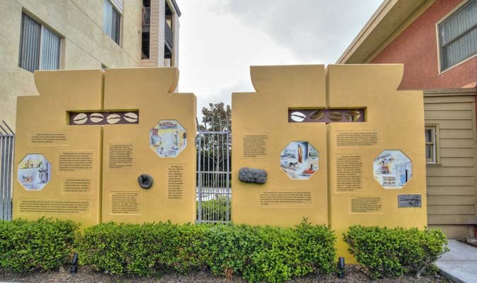 a large yellow wall with different informational signs in front of a building