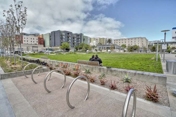 two people sitting on a bench in a park