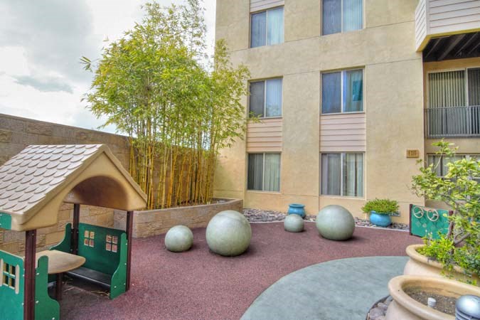 a courtyard with a building and some balls and trees