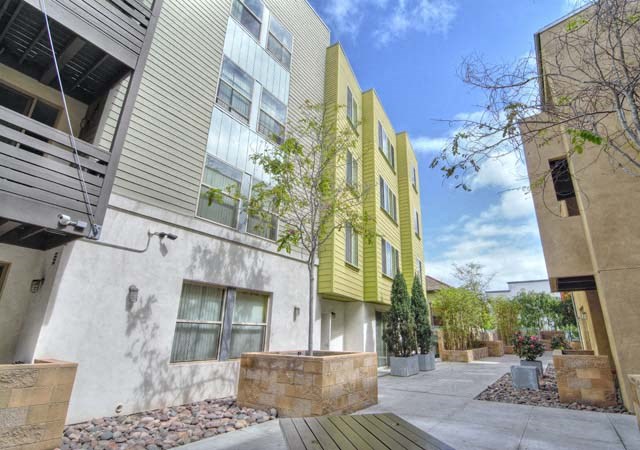 a yellow and white apartment building with a sidewalk