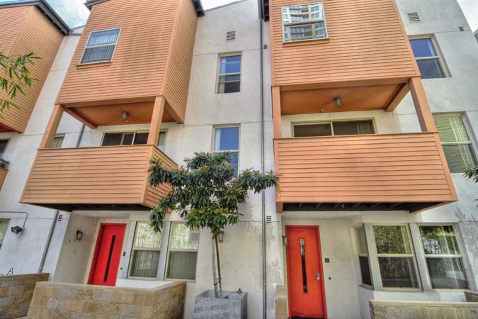a building with red doors and a tree in front of it