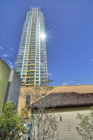 a tall building with the sun shining on the top of it