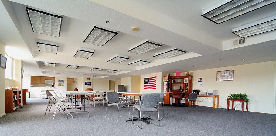 a large room with chairs and tables and lights in the ceiling