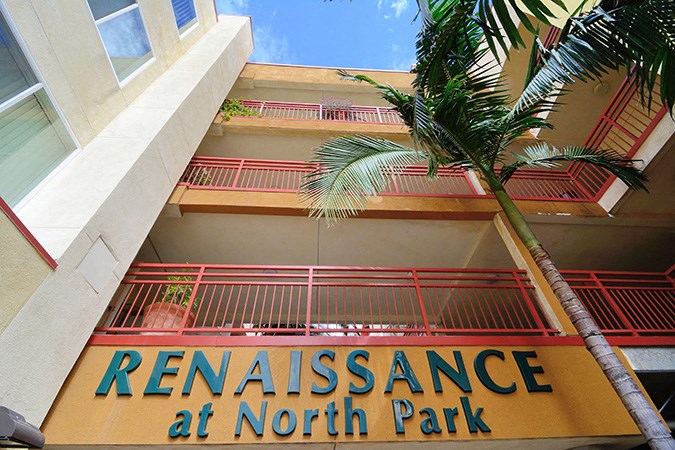 the facade of the renaissance at north park building with a palm tree