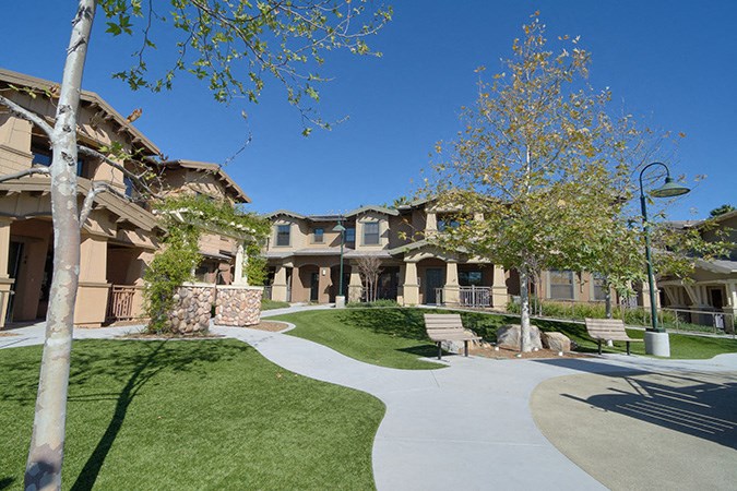 a group of houses with a walkway and grass