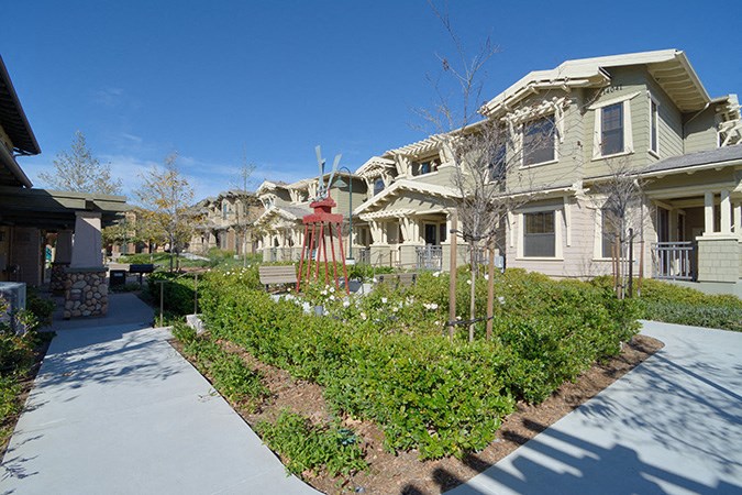 a row of houses with a sidewalk in front of them