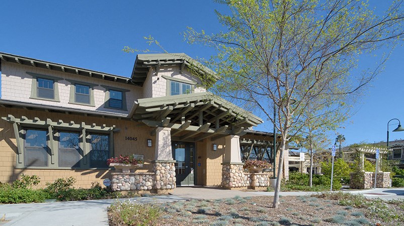 a building with a porch and a sidewalk in front of it