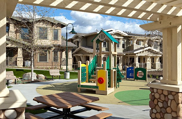 a playground with a picnic table in front of a house