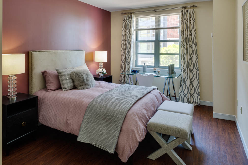 a bedroom with a bed and a desk and a window