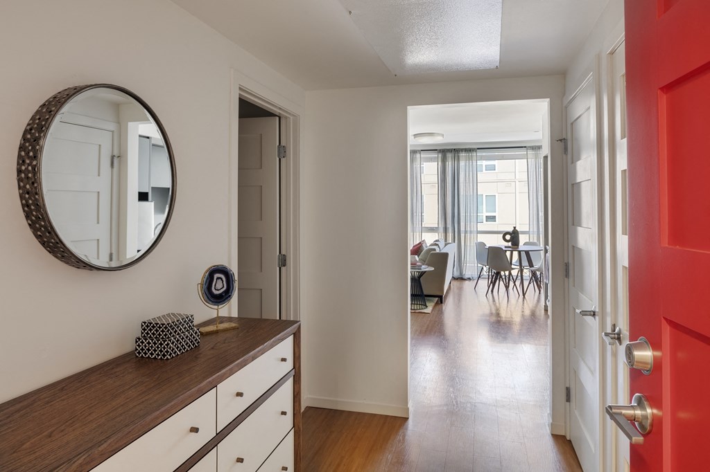 a living room and dining room with a mirror and a red door