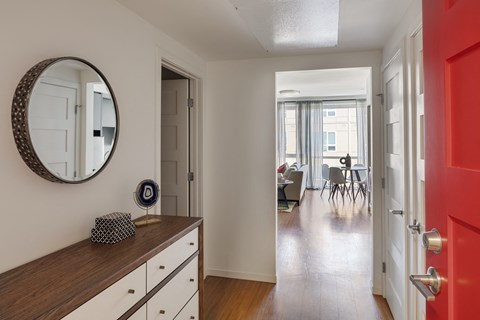 a living room and dining room with a mirror and a red door
