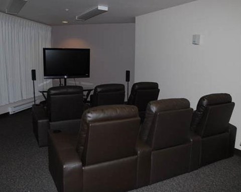 a living room with leather chairs and a television