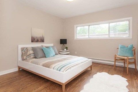 A bedroom with a large bed and a chair.