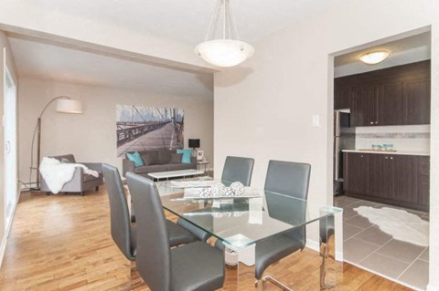 A modern dining room with a glass table and chairs.