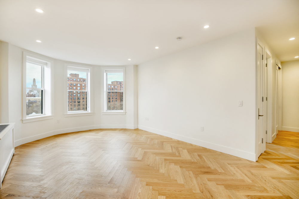 a living room with a hardwood floor and white walls