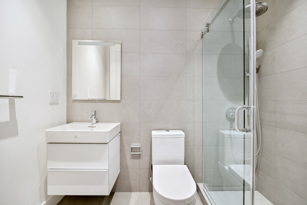 a white bathroom with a shower sink and toilet