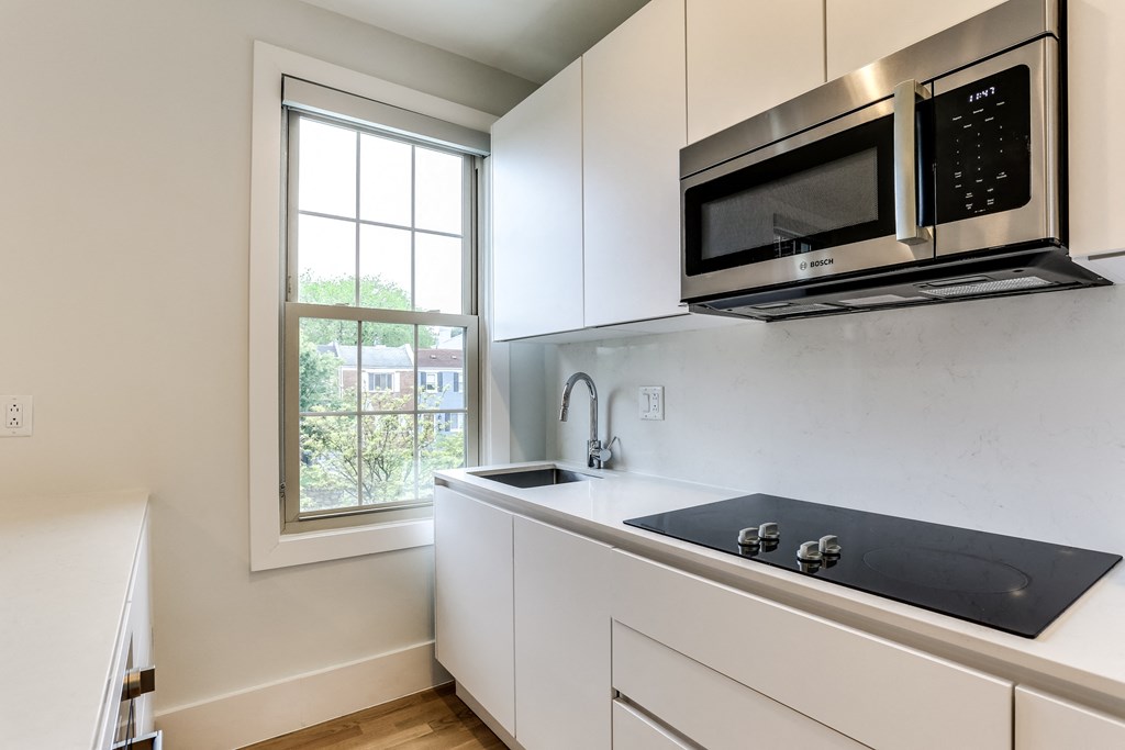 a kitchen with a sink and a microwave and a window