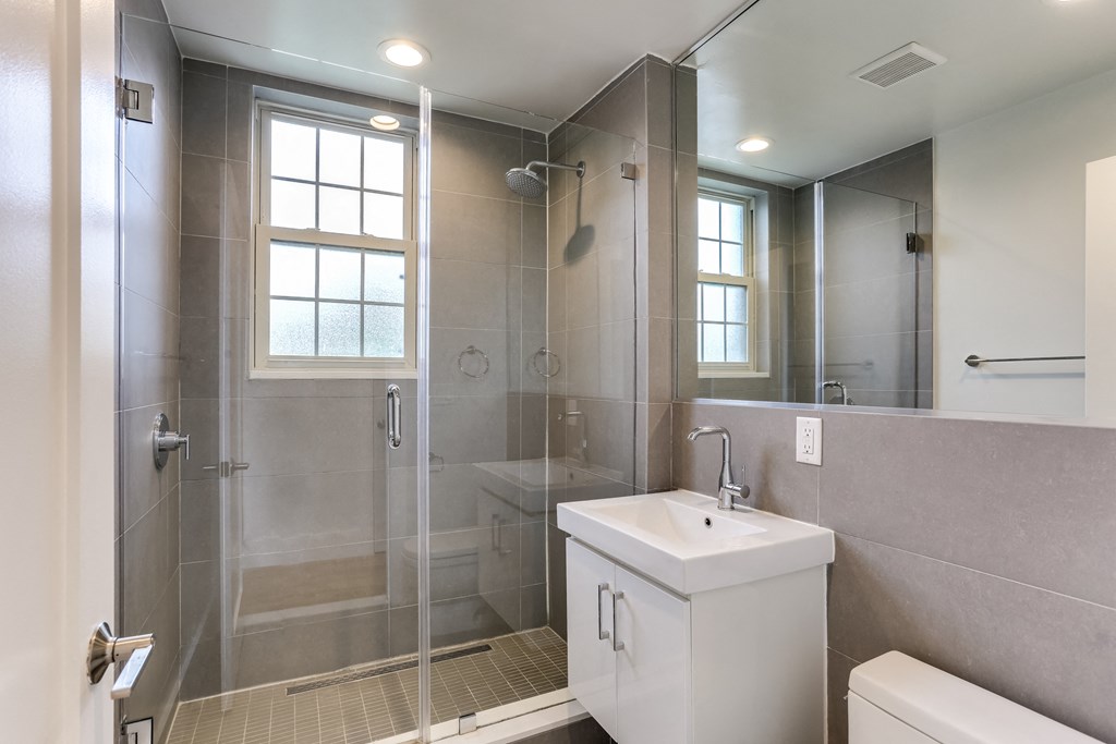 a bathroom with a shower and a sink and a mirror