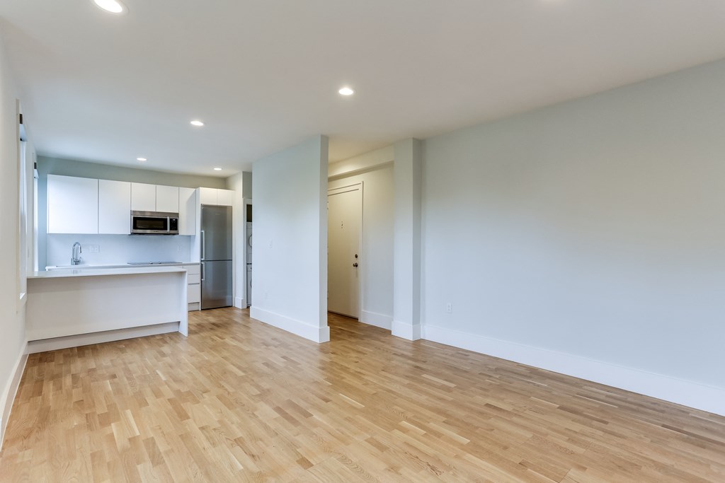 a living room with a hard wood floor and a kitchen