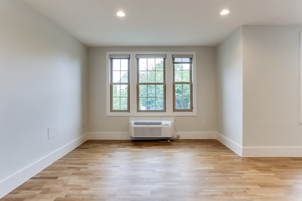 an empty living room with white walls and a window