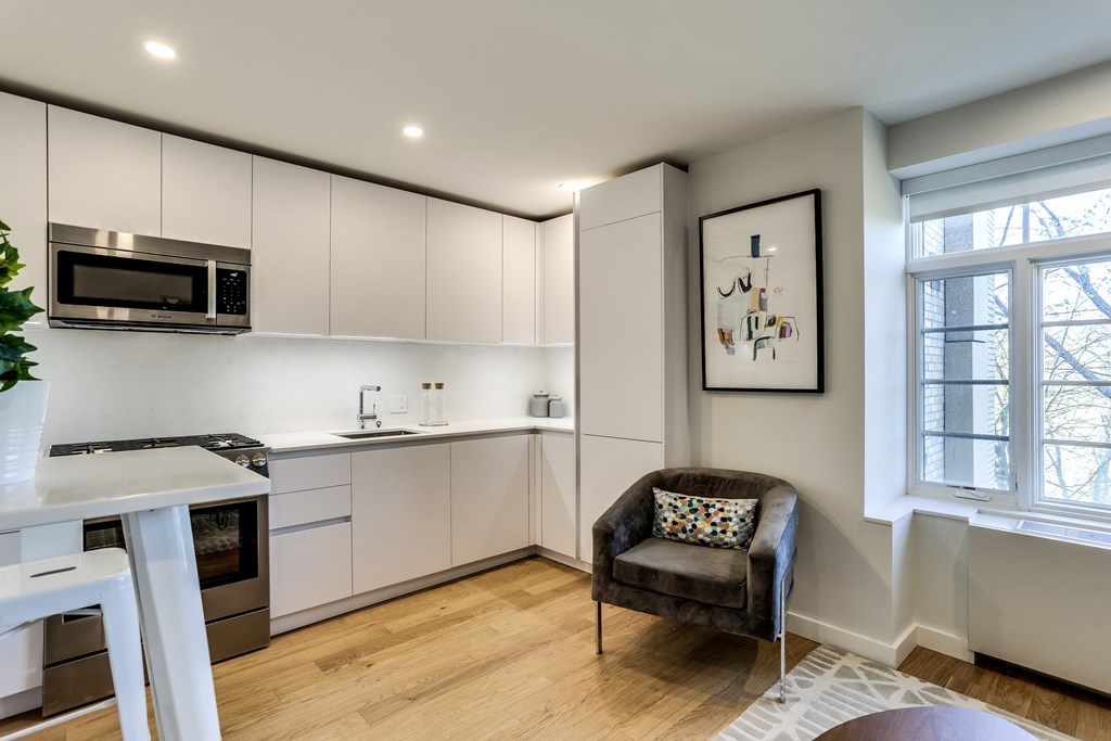 a kitchen with white cabinets and a table and a chair