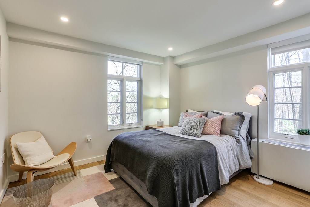 a bedroom with a bed and two windows