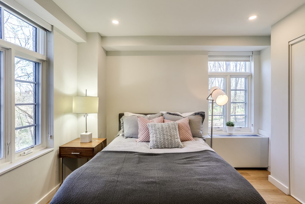 a bedroom with a bed and two windows