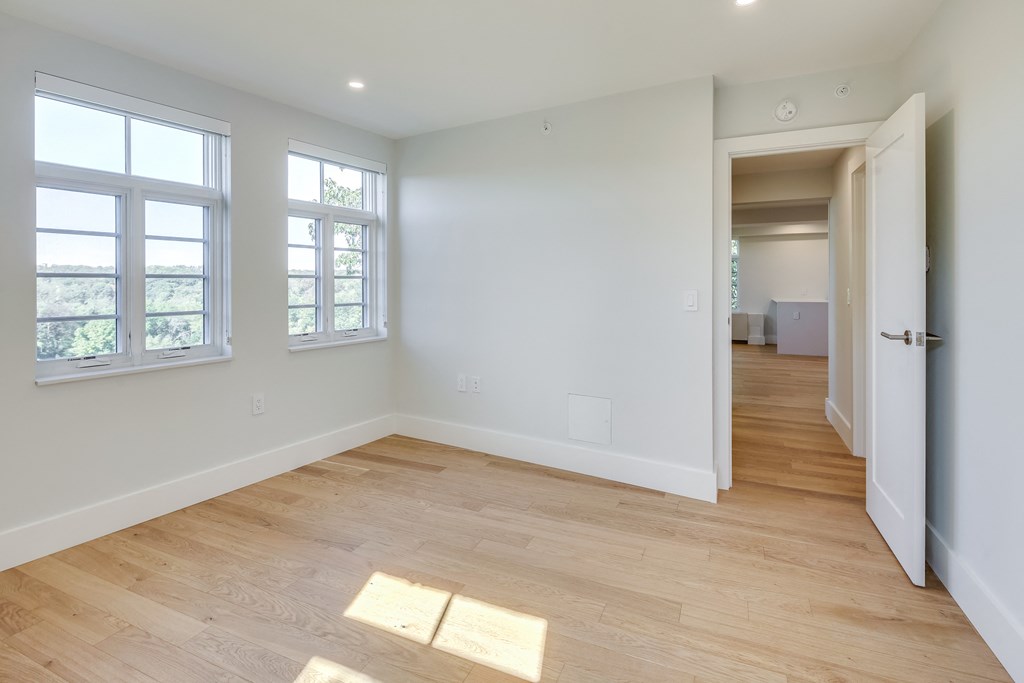 an empty living room with white walls and wood flooring