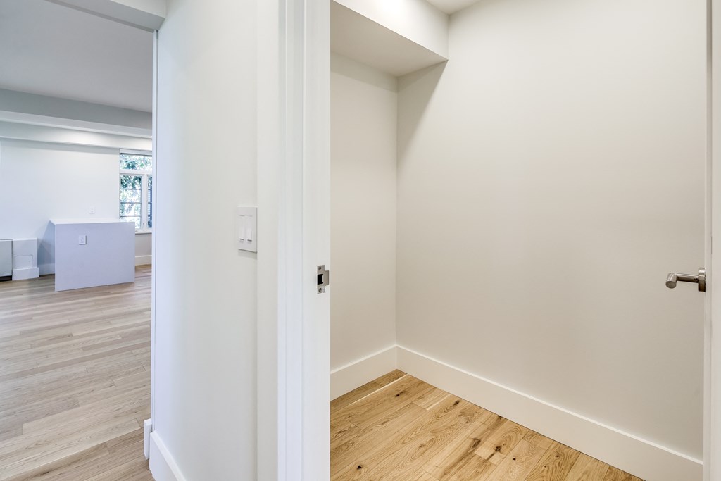 an empty room with white walls and a wooden floor