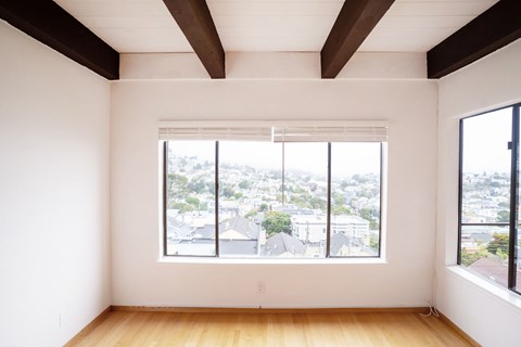 A room with a large window overlooking a cityscape.