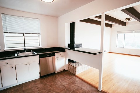 A kitchen with white cabinets and a black countertop.