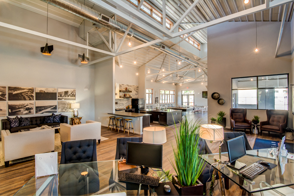 Leasing Office and Clubhouse with White Armchairs on Area Rug with Coffee Tables at Aviator at Brooks, San Antonio, Texas