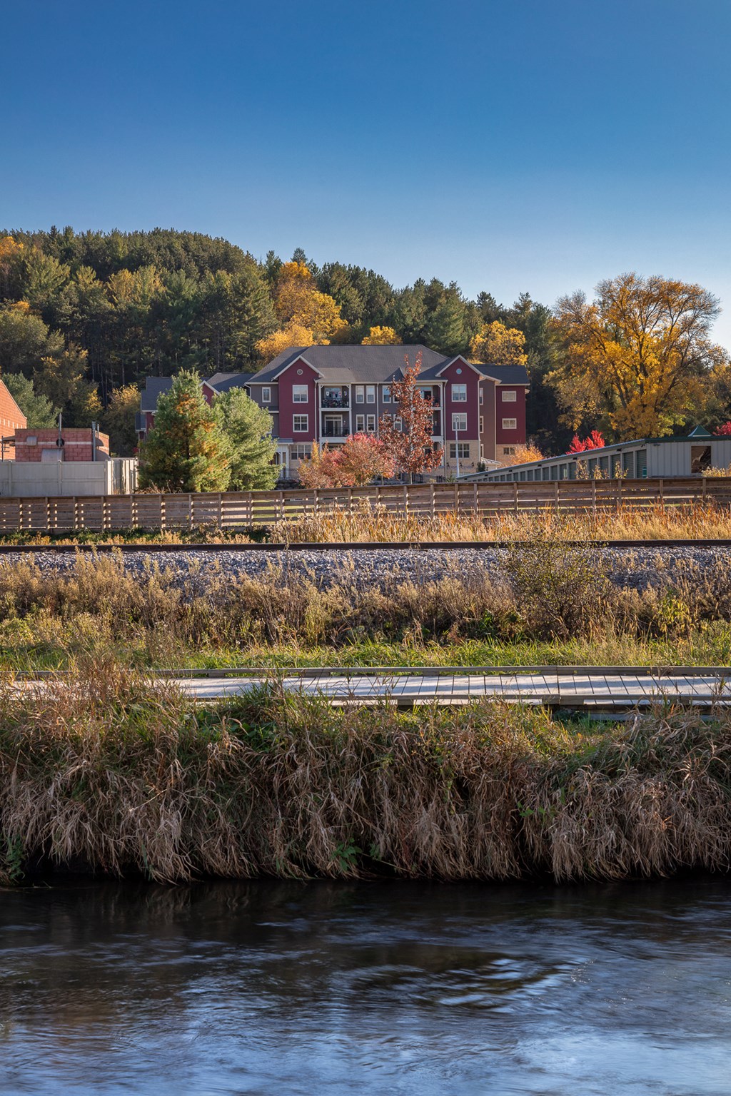 a view of a house and train tracks next to a river