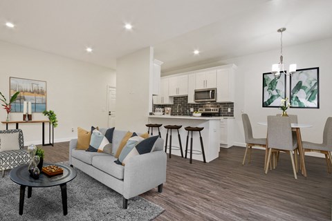 A modern living room with a grey couch and a black coffee table.
