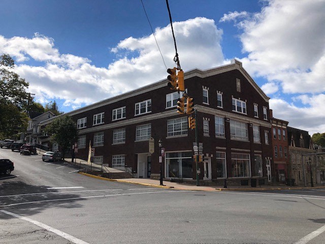 a traffic light at an intersection in front of a brick building
