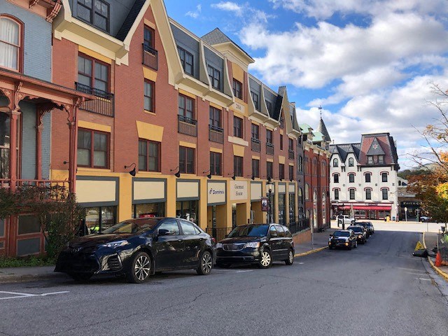 State College Apts a street with cars parked in front of a building
