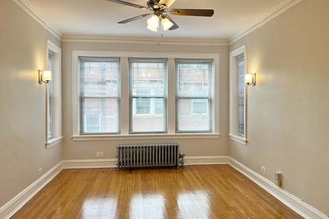 A room with a ceiling fan and a radiator on the floor.