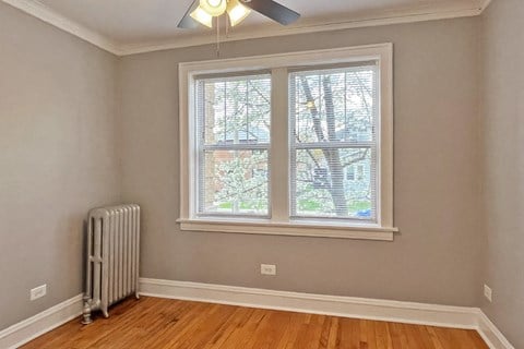 A room with a window and a radiator on the floor.