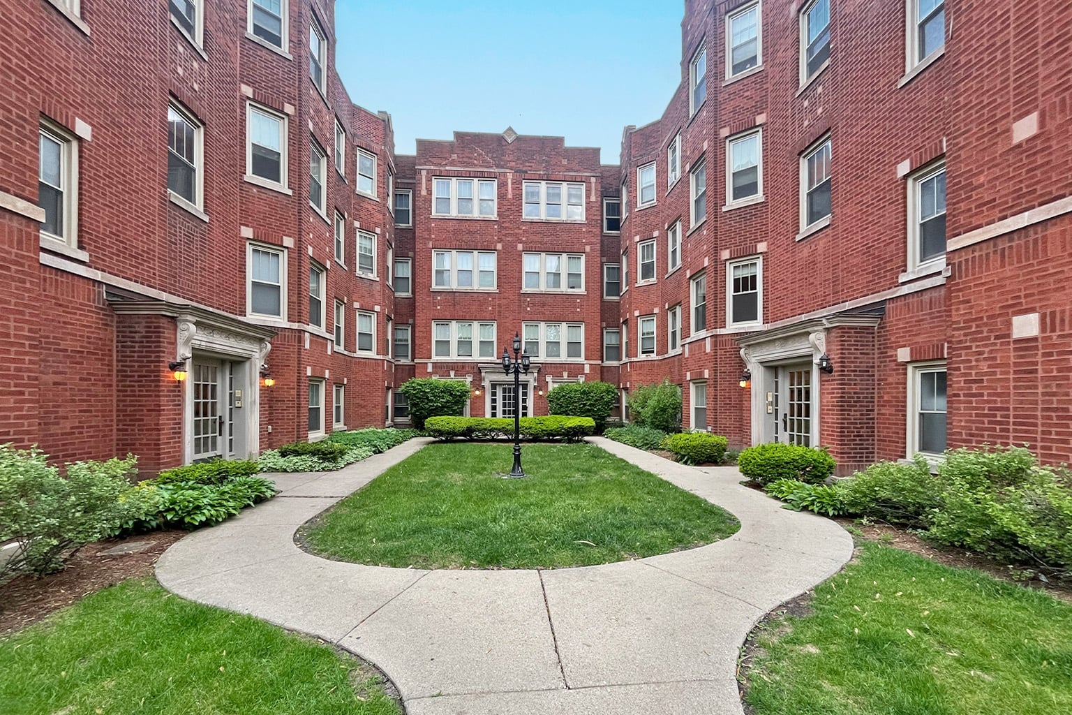 A courtyard surrounded by red brick buildings.