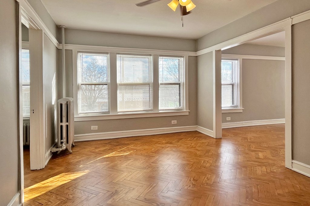 A room with wooden flooring and a ceiling fan.