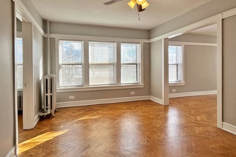 A room with wooden flooring and a ceiling fan.